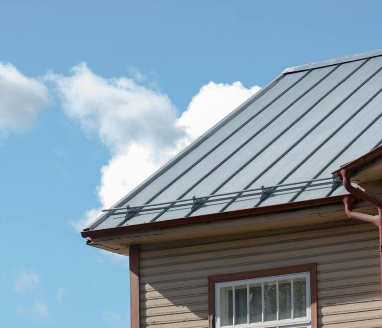 Close-up of a wooden building with metal roof and window in sunny Tartu, Estonia.
