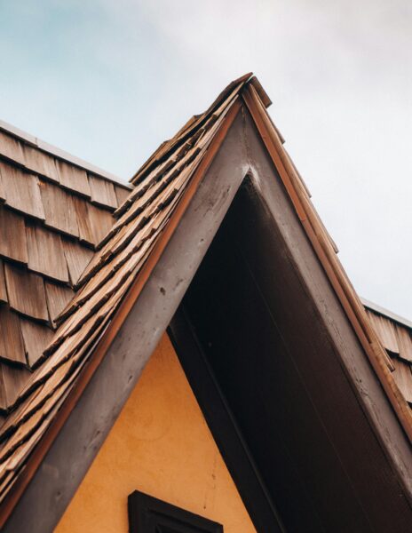 Detailed shot of a gable roof with rustic wooden shingles, showcasing architectural detail.
